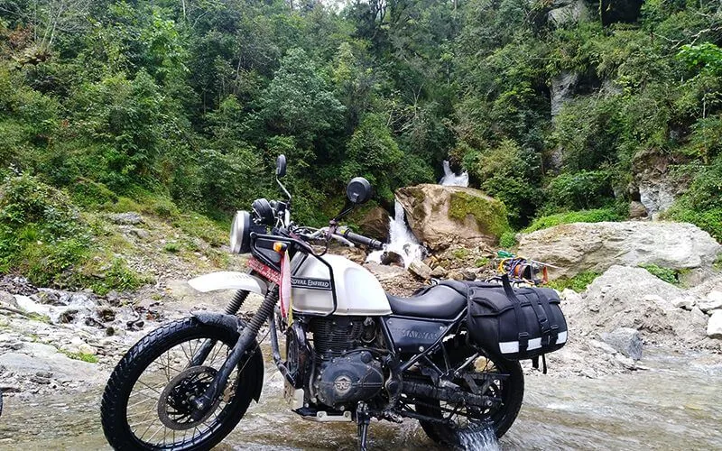 Royal Enfield près d’un torrent en zone forestière
