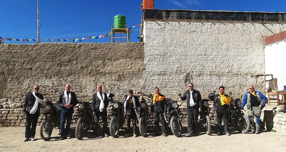 Groupe de motards et partenaires locaux devant leurs motos