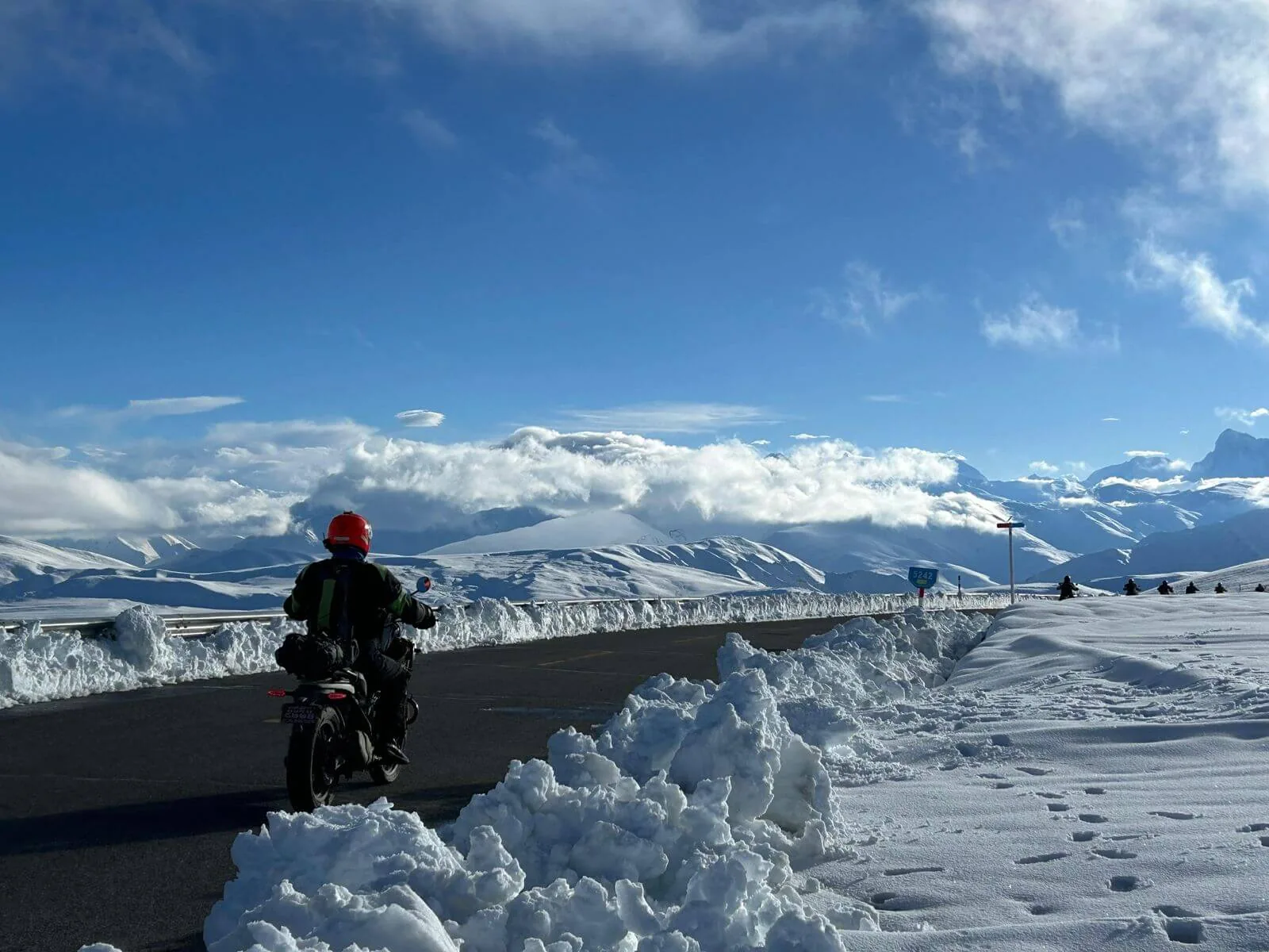 Motard sur une route bordée de neige